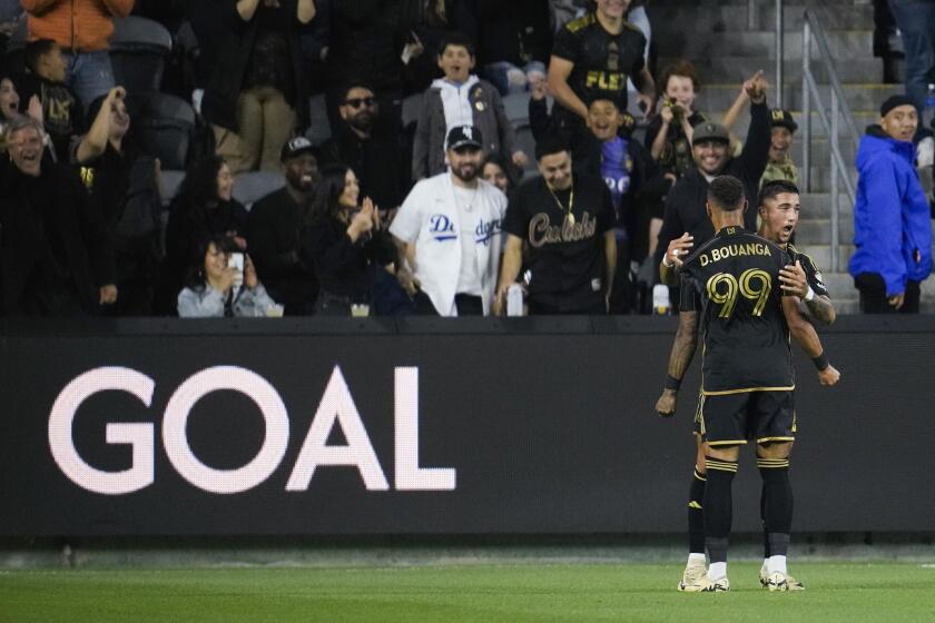 Los Angeles FC forward Denis Bouanga (99) celebrates with forward Cristian Olivera after scoring during the first half of an MLS soccer match against the Vancouver Whitecaps in Los Angeles, Saturday, May 11, 2024. (AP Photo/Ashley Landis)