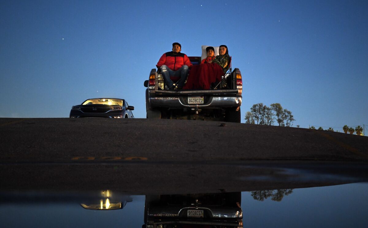 Sal Barbosa, left, Nathan Barbosa and DiAngelo Lujano watch a movie at Paramount Drive-In on Tuesday. 