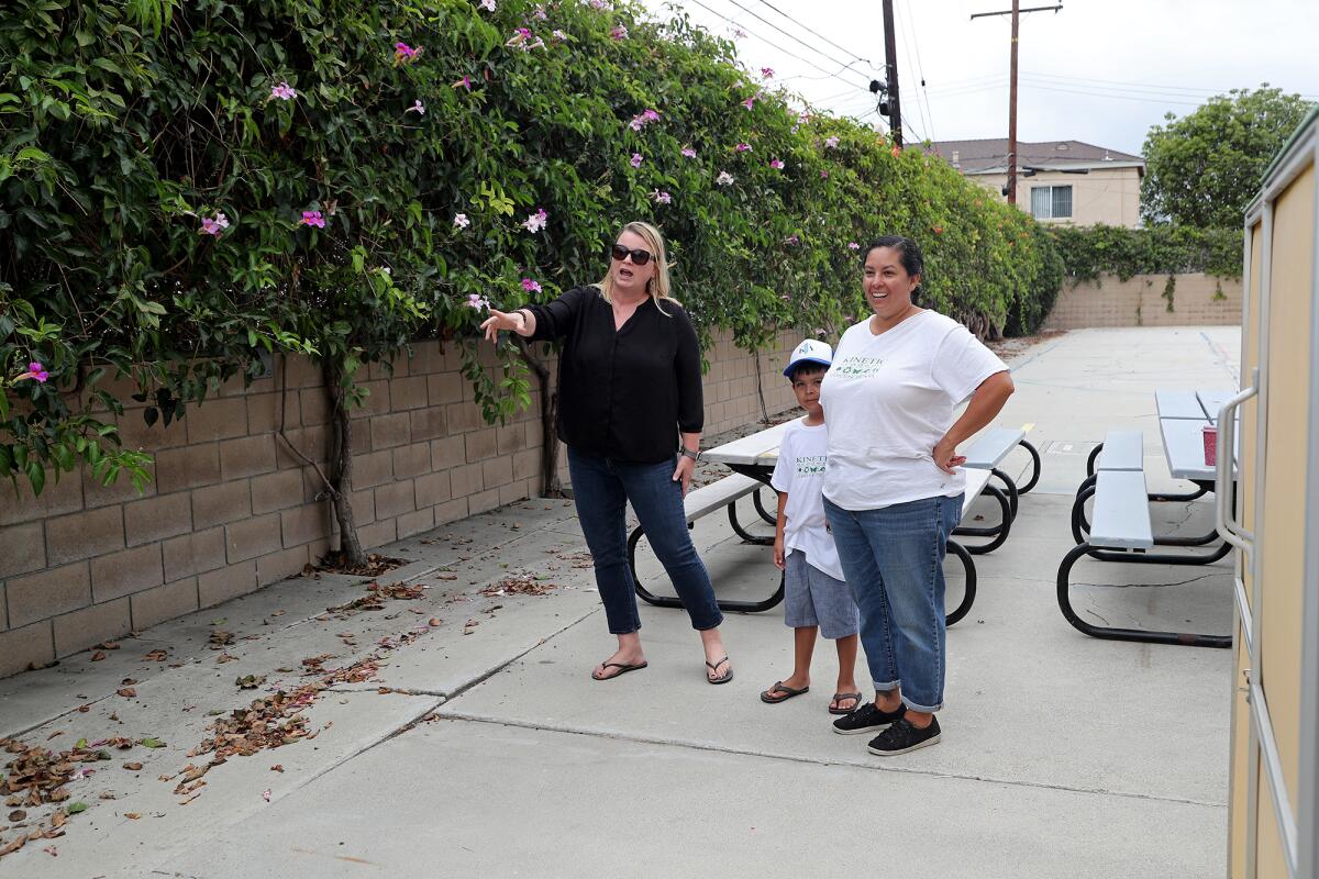 Claire Anderson, left, with Waves of Kindness, points out a space that Daya Oyarzabal and her son Salvador can use.