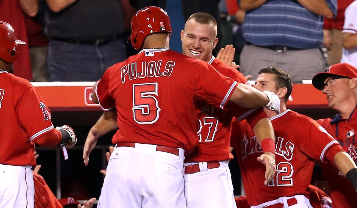 Angels' Albert Pujols is greeted by Mike Trout as he returns to the dugout after hitting a two-run home run during a 7-3 win over the Tampa Bay Rays on Monday.