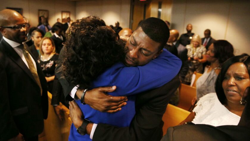 Odell Edwards hugs D.A. Faith Johnson after a Dallas police officer was convicted of killing Edwards' son.