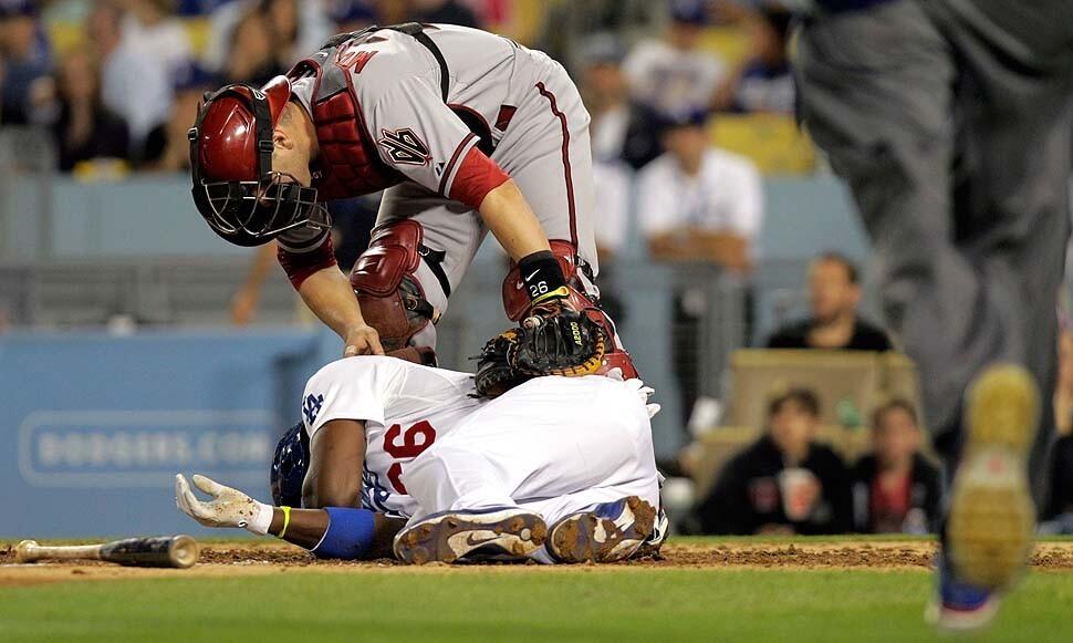 Arizona Diamondbacks catcher Miguel Montero (26) tends to Los Angeles Dodgers right fielder Yasiel Puig (66), who was hit by a pitch thrown by Arizona Diamondbacks starting pitcher Ian Kennedy (31) in the sixth inning.