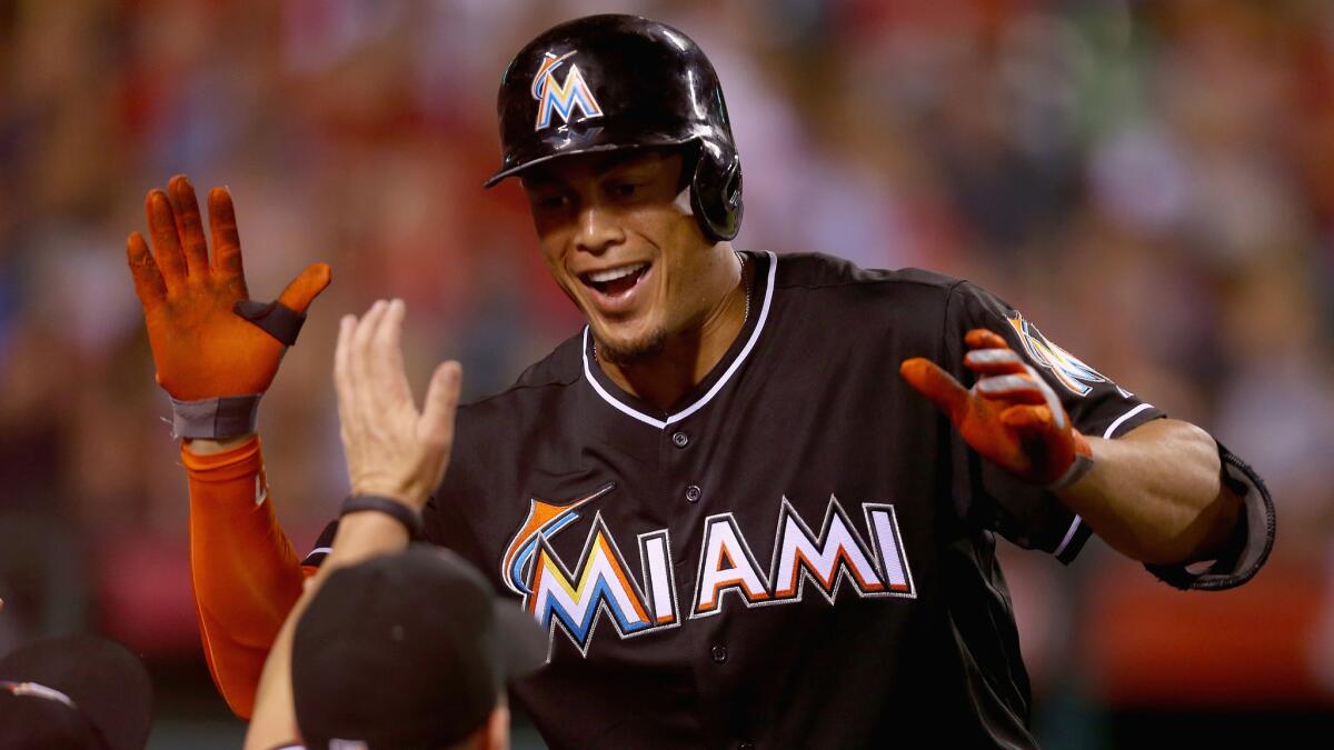 Marlins right fielder Giancarlo Stanton celebrates with his teammates after hitting a three-run home run against the Angels in the fourth inning of Monday's game.