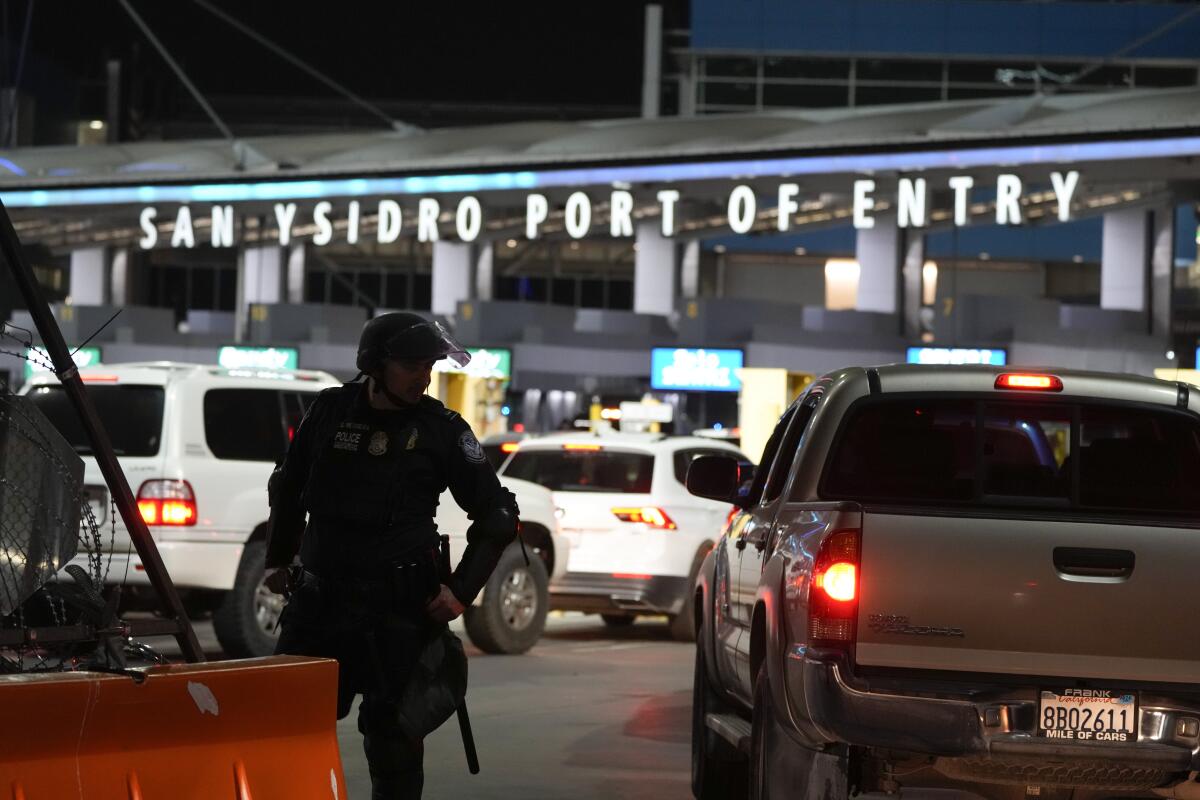 A U.S Customs and Border Protection official standing among the lanes of cars entering the San Ysidro Port of Entry.