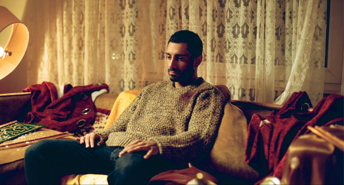 Riz Ahmed sits looking troubled in the live-action short film "The Long Goodbye." 