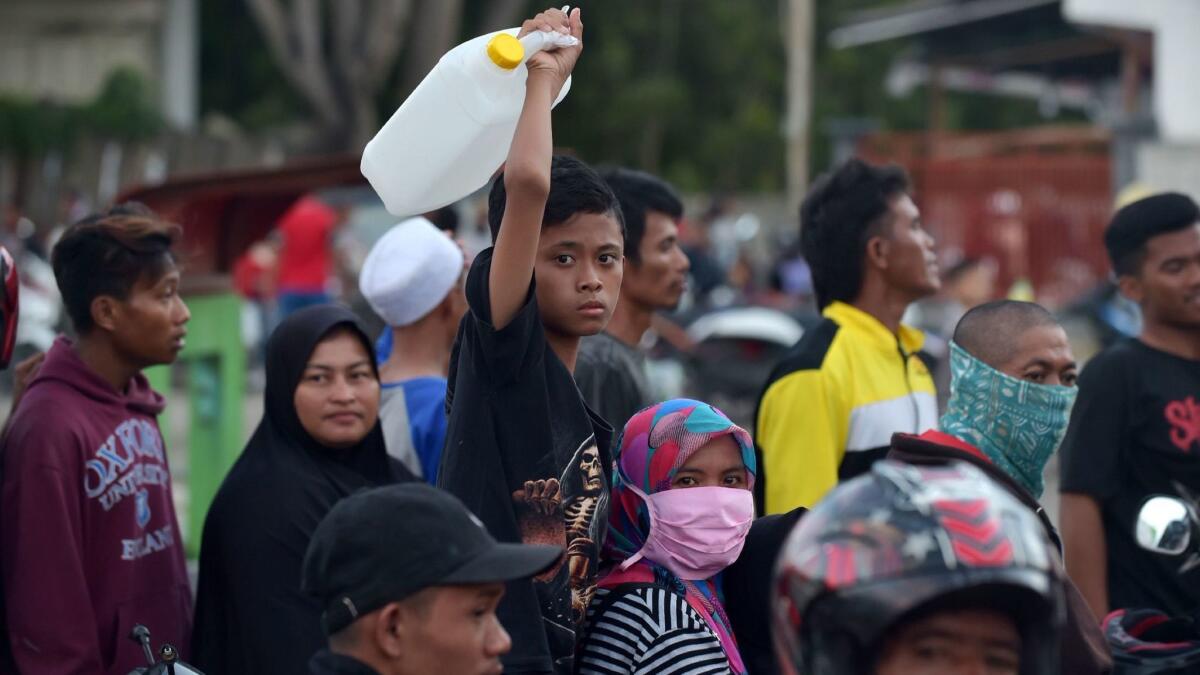 People queue for gasoline in Palu, Indonesia's Central Sulawesi on Monday.