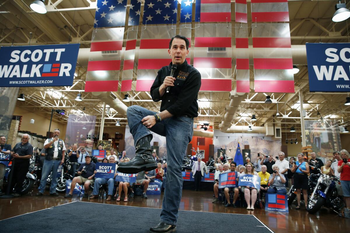 Republican presidential candidate, Wisconsin Gov. Scott Walker, shows off his biker boots during a campaign event at a Harley-Davidson dealership Tuesday, July 14, 2015, in Las Vegas. (AP Photo/John Locher)