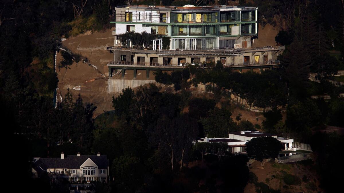 The unfinished mansion towers over a pair of homes in Bel-Air.