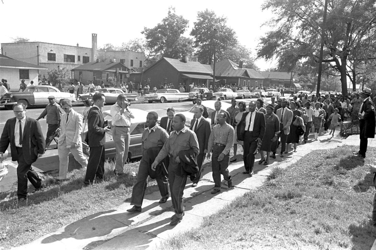 FILE - Rev. Ralph Abernathy, left, and Rev. Martin Luther King Jr. lead a column of demonstrators as they attempt to march on Birmingham, Ala., city hall April 12, 1963. Police intercepted the group short of their goal. Rev. Jonathan McPherson, shown in a coat and tie two people behind King, in 2021 is urging protesters against racial injustice to "keep on keeping on." (AP Photo/Horace Cort)