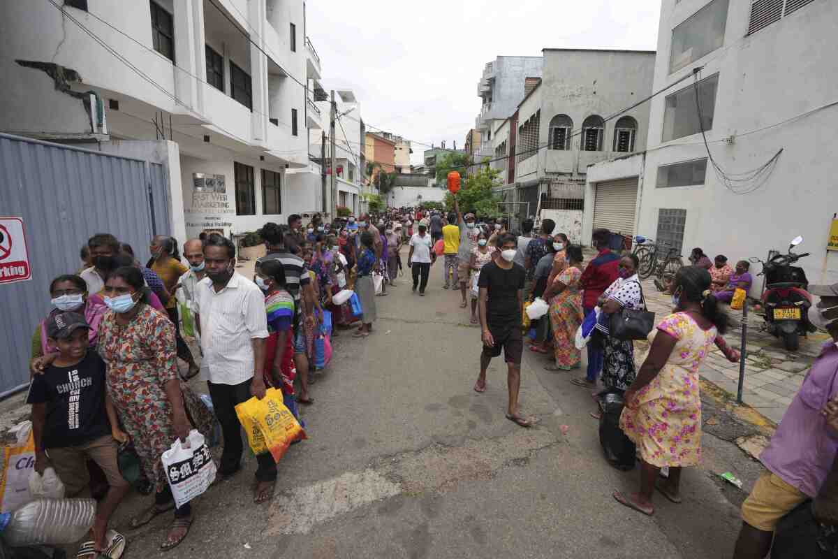 FILE - Sri Lankans queue up near a fuel station to buy kerosene in Colombo, Sri Lanka, Tuesday, April 12, 2022. When the Federal Reserve raises interest rates -- as it did Wednesday, May 4, 2022 -- the impact doesn’t stop with U.S. homebuyers paying more for mortgages or Main Street business owners facing costlier bank loans. The fallout can be felt beyond America’s borders, hitting shopkeepers in Sri Lanka, farmers in Mozambique and families in poorer countries around the world. (AP Photo/Eranga Jayawardena, File)