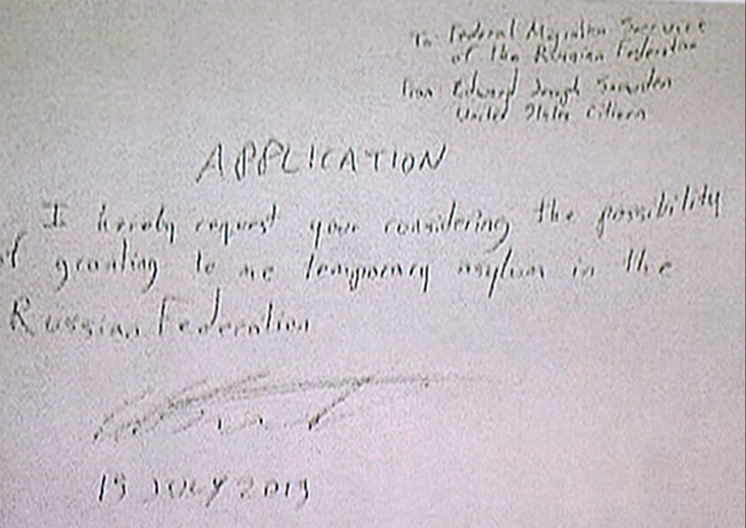 In this image made from video, a document purportedly written by National Security Agency leaker Edward Snowden reads, "To: Federal Migration Service of the Russian Federation, From: Edward Joseph Snowden, United States citizen. APPLICATION I hereby request you considering the possibility of granting to me temporary asylum in the Russian Federation. 15 July 2013."