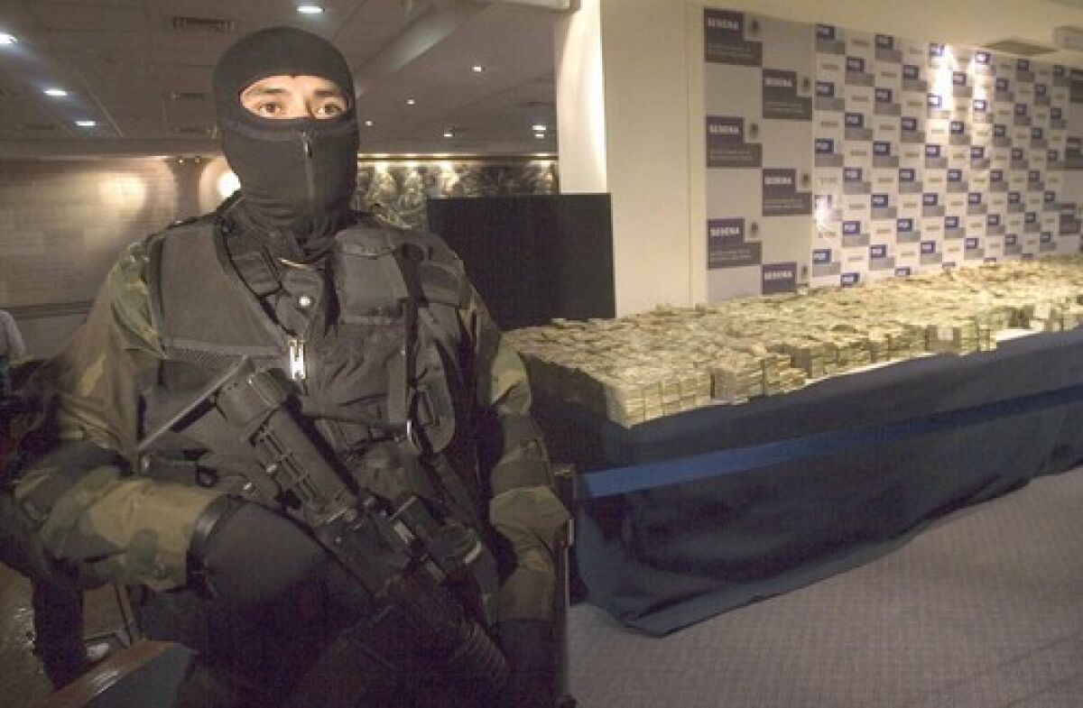 A Mexican army guard stands in front of $26.2 million seized from a house in northwestern Sinaloa state, it was the second largest cash haul in the country's history.
