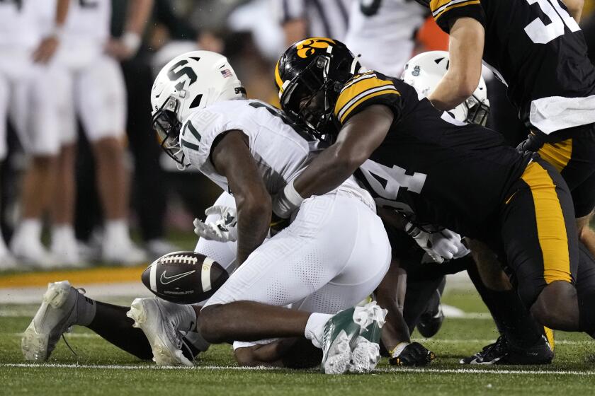 Michigan State wide receiver Tre Mosley (17) fumbles as he is tackled by Iowa linebacker Jay Higgins (34) during the second half of an NCAA college football game, Saturday, Sept. 30, 2023, in Iowa City, Iowa. Iowa won 26-16. (AP Photo/Charlie Neibergall)