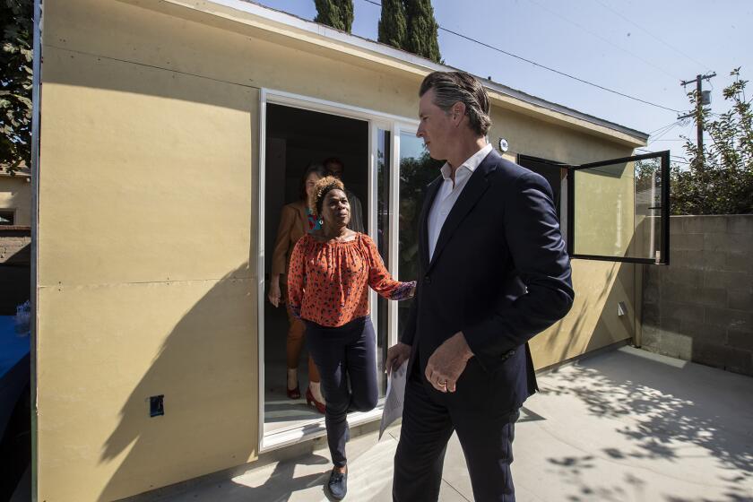 LOS ANGELES, CALIF. -- WEDNESDAY, OCTOBER 9, 2019: California governor Gavin Newsom, right, chats with Felicia Smith, left, after a tour of her new garage conversion under construction in Los Angeles, Calif., on Oct. 9, 2019. The governor signed several housing bills in Smith’s backyard, where builders are converting her garage into a rental unit. (Brian van der Brug / Los Angeles Times)