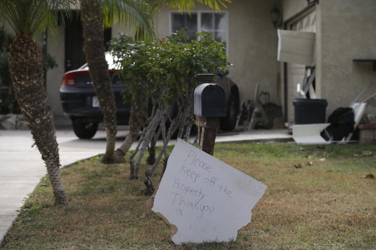 A sign stands in front of a mailbox at Enrique Marquez's home, Wednesday, Dec. 9, 2015, in Riverside, Calif. Authorities have said Enrique Marquez, an old friend of San Bernardino attacker Syed Farook, purchased two assault rifles used in last week's fatal shooting that killed 14 people.