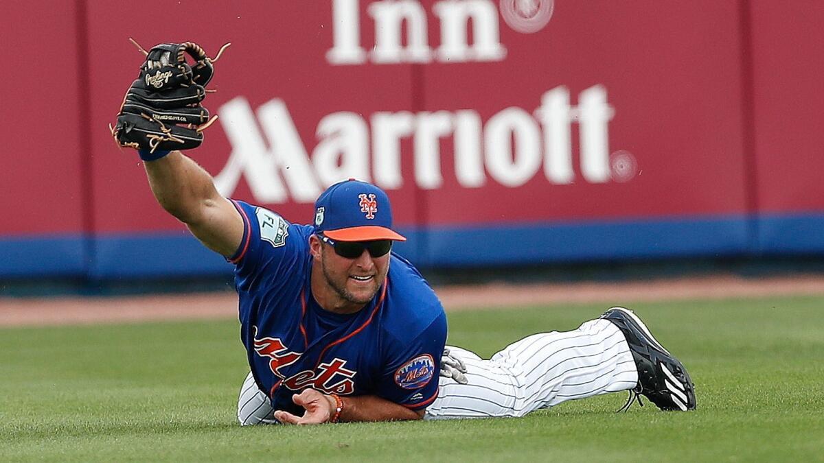 New York Mets fielder Tim Tebow makes a diving catch on a fly ball by Miami's Justin Bour during an exhibition game on March 13.
