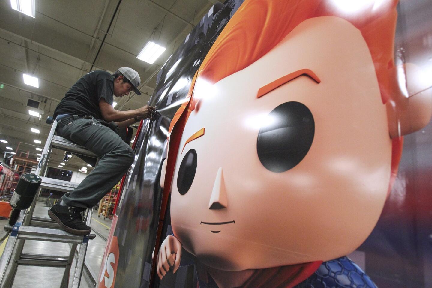 Anthony Soltero puts on a section of transit vinyl as he and a crew put on an advertising wrap for TBS television host Conan O'Brien's talk show on a trolley car.