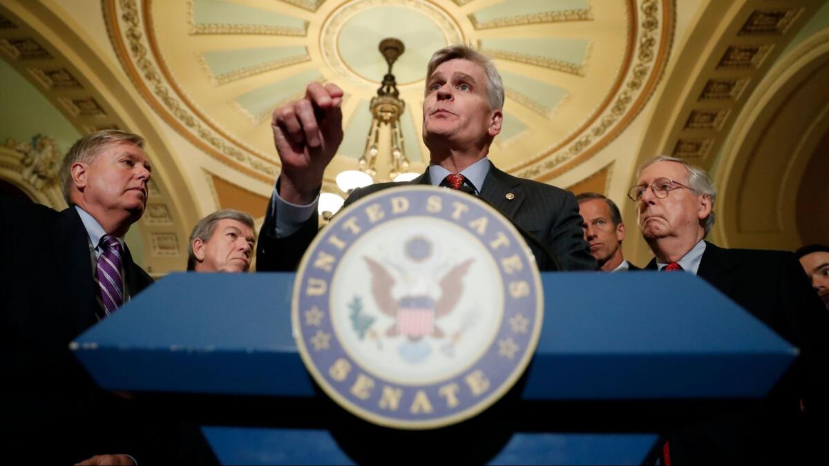 Sen. Bill Cassidy, R-La., center, speaks to the media, accompanied by Sen. Lindsey Graham, R-S.C., left, and Senate Majority Leader Mitch McConnell on Capitol Hill in Washington on Sept. 19.