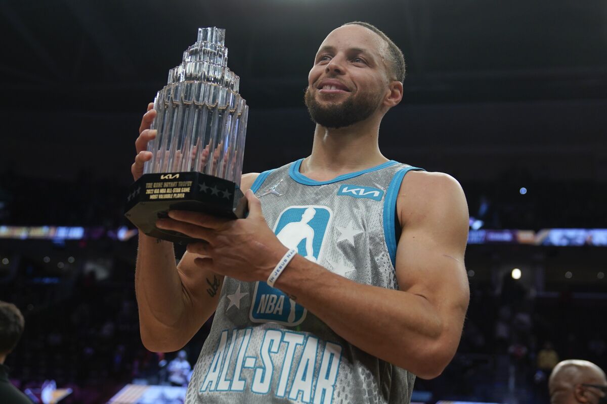 Golden State's Stephen Curry holds up the Kobe Bryant Trophy after being named the MVP of the NBA All-Star Game.