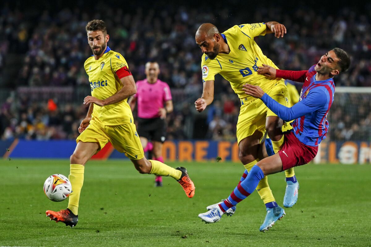 Barcelona's Ferran Torres, right, vies for the ball with Cadiz's Fali during a Spanish La Liga soccer match between FC Barcelona and Cadiz at the Camp Nou stadium in Barcelona, Spain, Monday, April 18, 2022. (AP Photo/Joan Monfort)