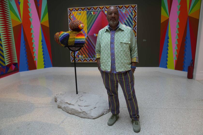 Artist Jeffrey Gibson poses inside the US pavilion during the media open day at the 60th Biennale of Arts in Venice, Italy, Tuesday, April 16, 2024. A Mississippi Choctaw of Cherokee descent, Gibson is the first Native American to represent the United States solo at the Venice Biennale, the world’s oldest contemporary art show. Gibson mixes Western modernism and Native American craft in his vibrantly hued paintings and sculptures. (AP Photo/Luca Bruno)