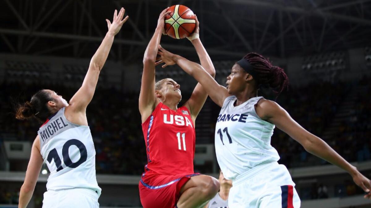 The United States' Elena Delle Donne, center, drives to the basket against French players Sarah Michel, left, and Valeriane Ayayi during Thursday's game.