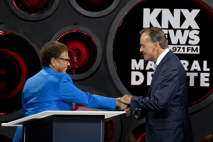 Los Angeles, CA - October 06: Los Angeles Mayoral candidates Congresswoman Karen Bass and builder Rick Caruso greet each other as they participate in the second one-on-one mayoral debate at the KNX Newsradio SoundSpace Stage in Los Angeles, Thursday, Oct. 6, 2022. (Allen J. Schaben / Los Angeles Times)
