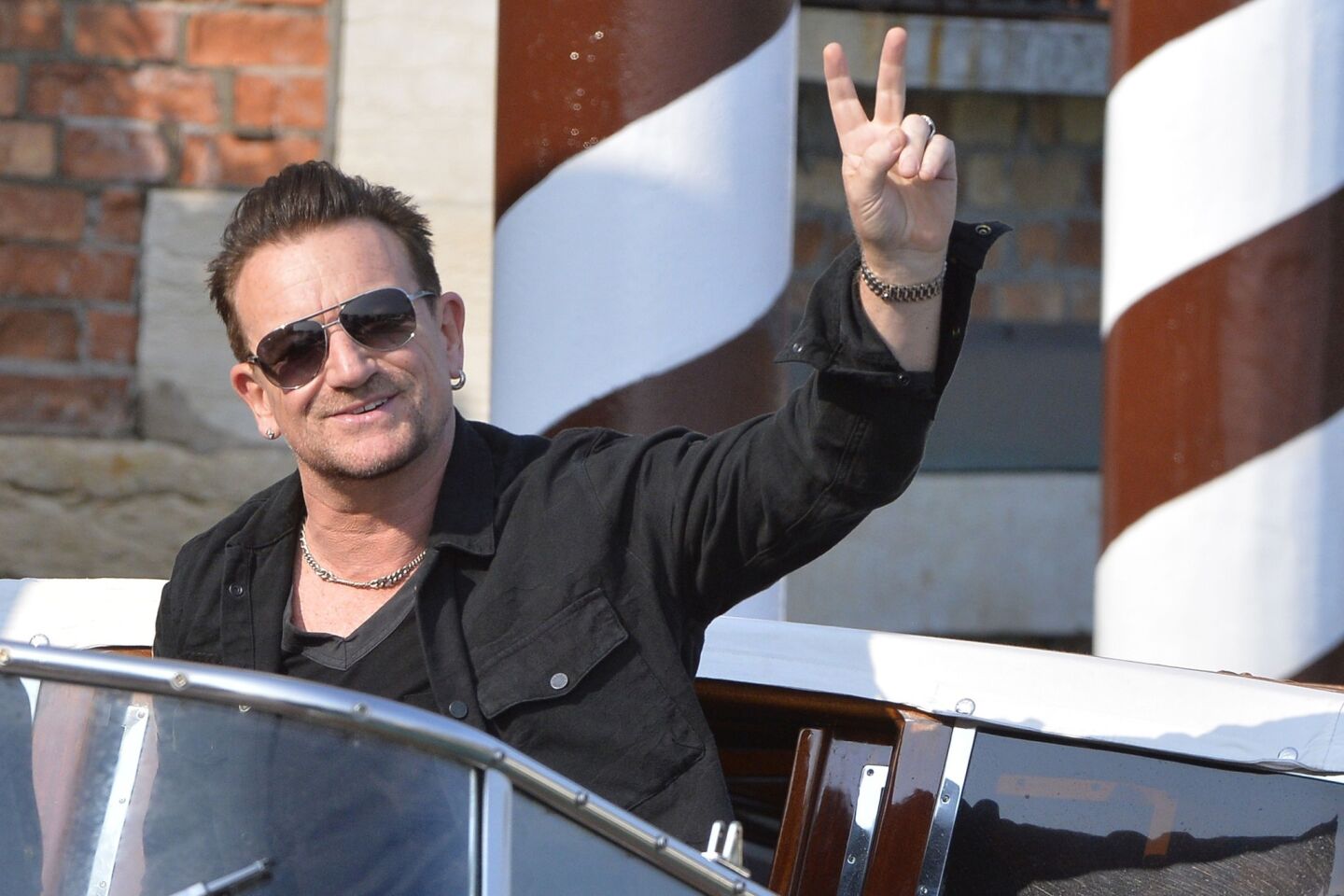Bono waves outside of the Cipriani Hotel in Venice on Saturday.