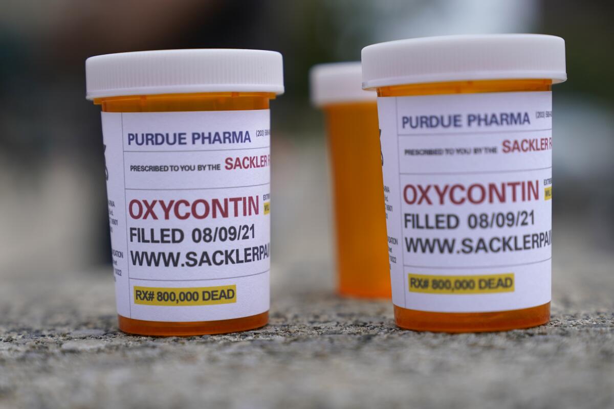 Fake pill bottles with messages about Purdue Pharma are displayed outside a courthouse 