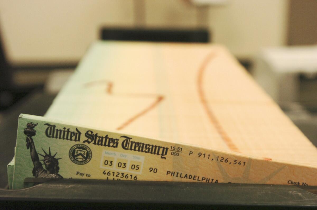 Monthly Social Security payments will rise 1.5% due to a cost of living adjustment, the Social Security Administration announced Wednesday. Above,trays of checks waiting to be mailed.