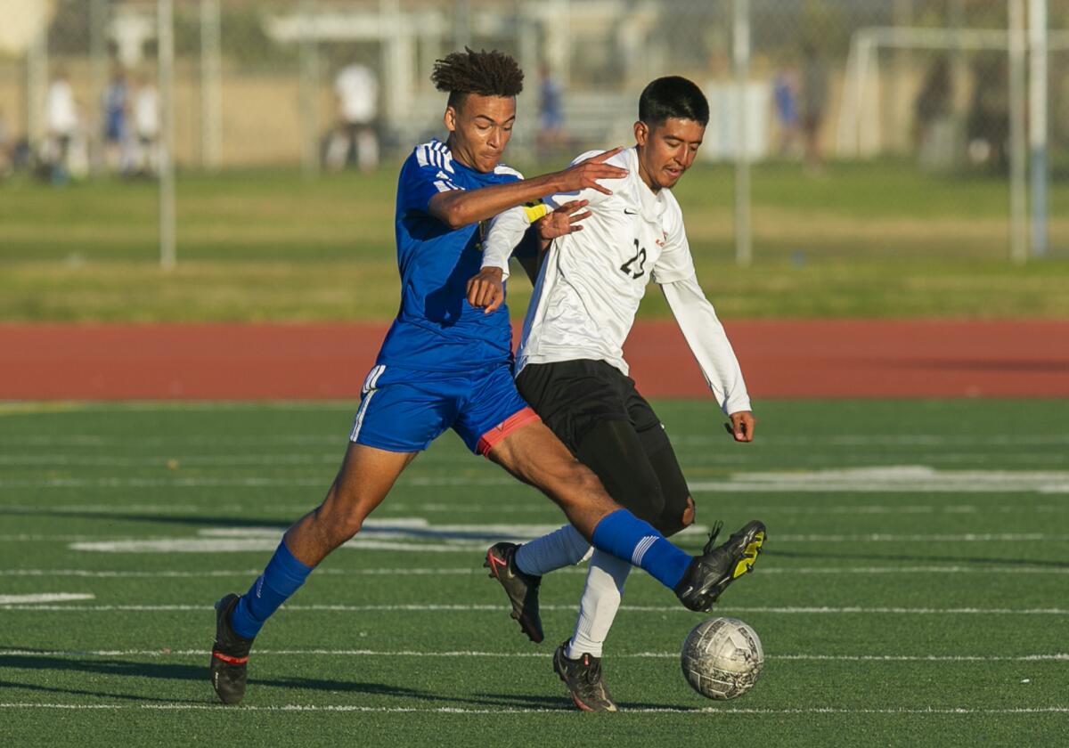 Fountain Valley's Micah Yanez, left, battles for a ball with Los Amigos' Levy Garcia during a nonleague boys' soccer match.