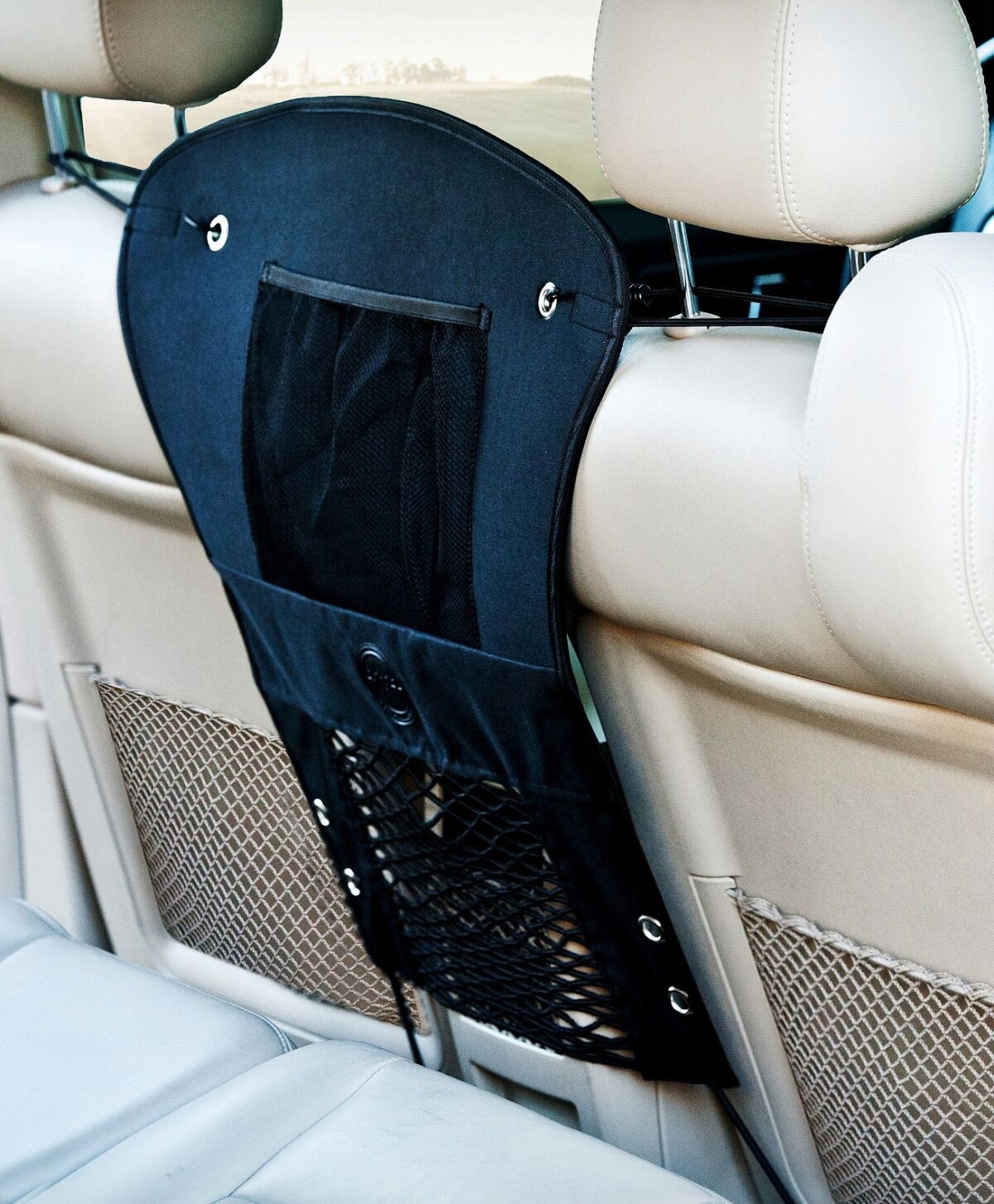 K&H Car Travel Safety Barrier attaches via elastic bungee cords that hook around the headrests and under the back of the front car seats.