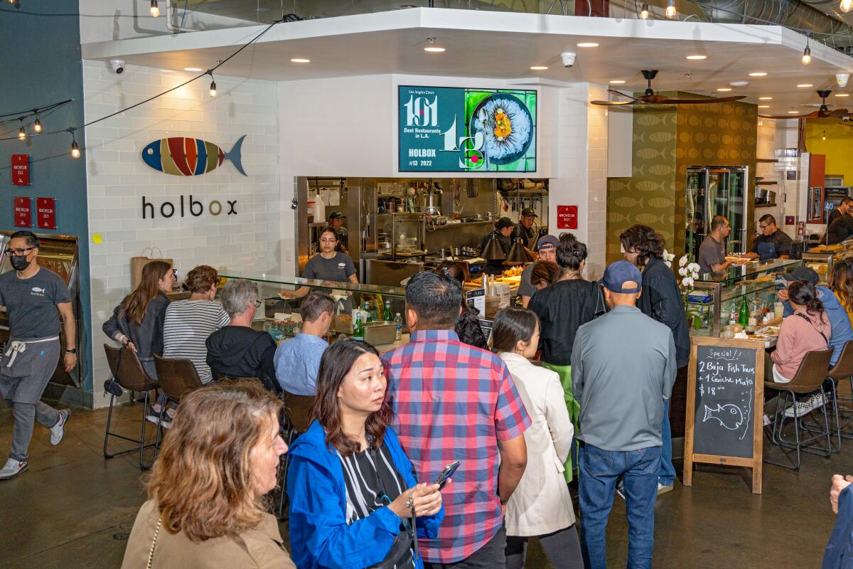 Eager diners line up during a weekend lunch rush at Holbox inside Mercado La Paloma. (Ron De Angelis / For The Times)