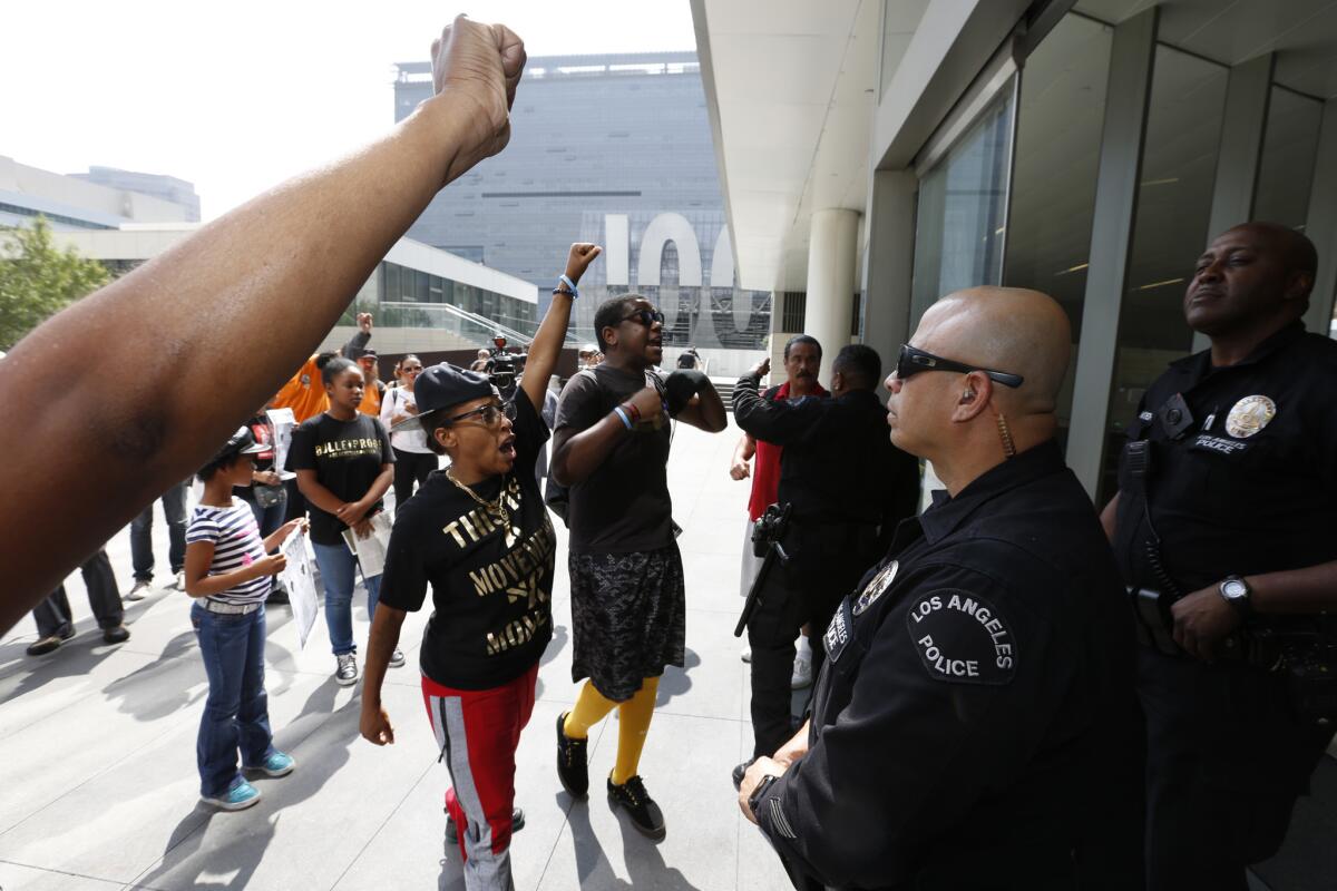 Protesters shout their message in the face of an LAPD officers after disrupting the Los Angeles Police Commission meeting on the one-year anniversary of Ezell Ford's death. Ford was a 25-year-old mentally ill black man who was shot dead by LAPD officers in August 2014.