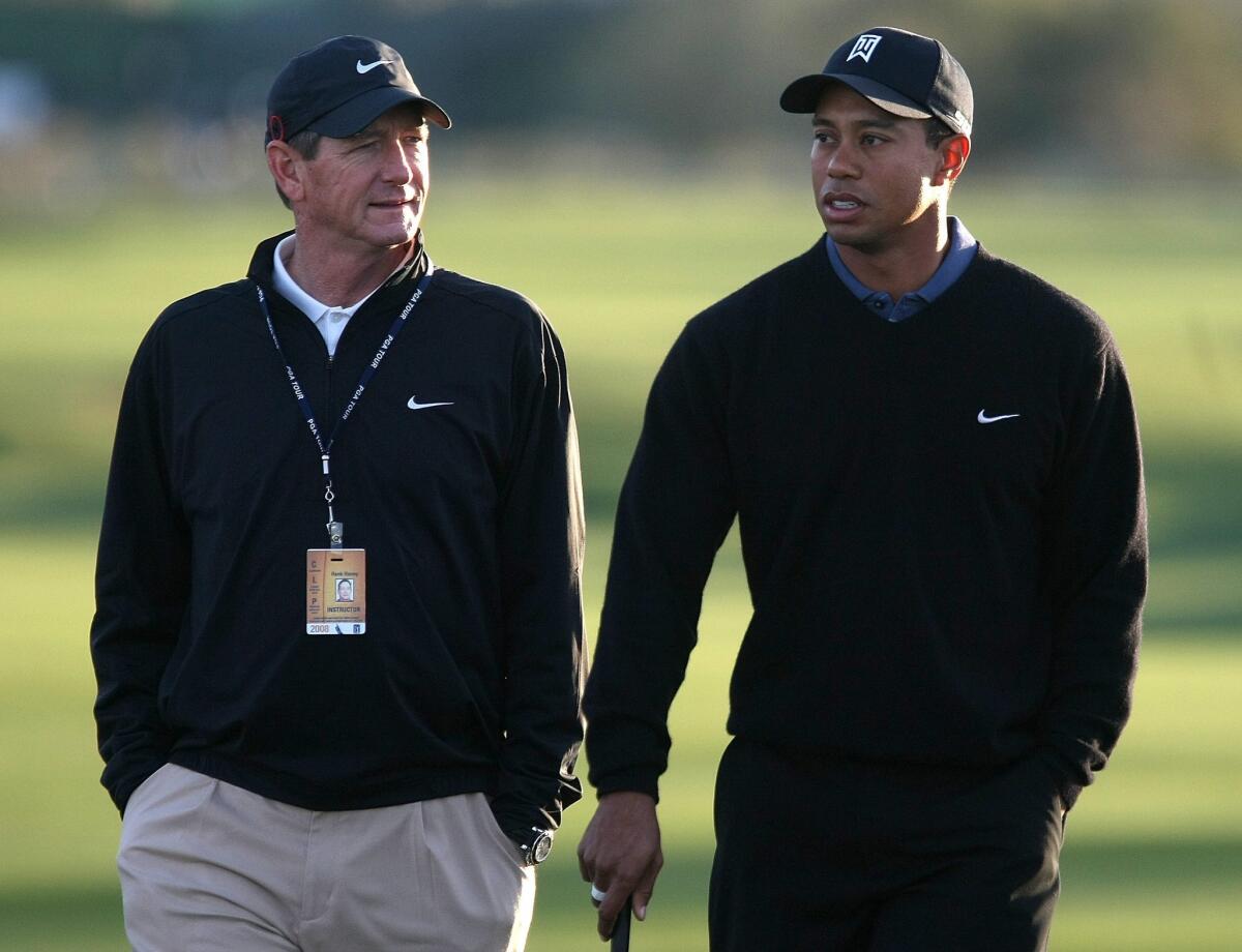 Tiger Woods walks with then-coach Hank Haney in 2008.