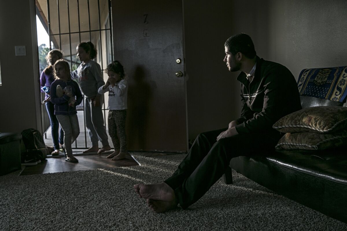 Mohammad Al Kard, 21, looks on as neighborhood children drop by to play with his sisters. He suffered a head injury from a bullet wound he sustained in Syria. His family sought refuge in the U.S. in an effort to provide him the best medical care possible.