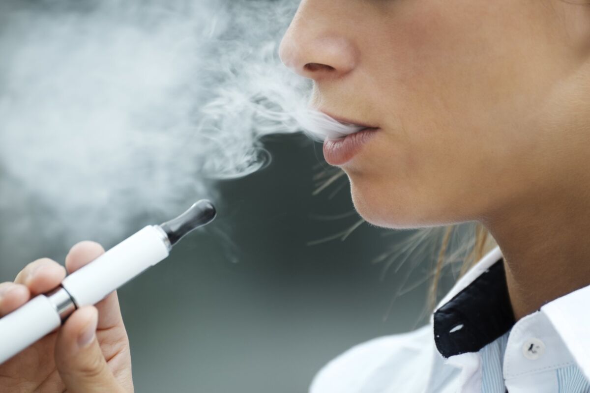 A young person is seen vaping.