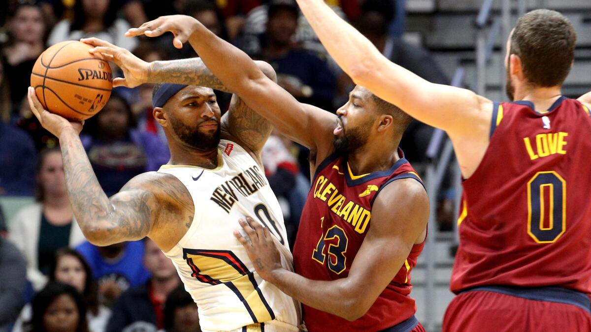 Pelicans center DeMarcus Cousins looks to pass against the double-team defense of Cleveland big men Tristan Thompson (13) and Kevin Love on Saturday.