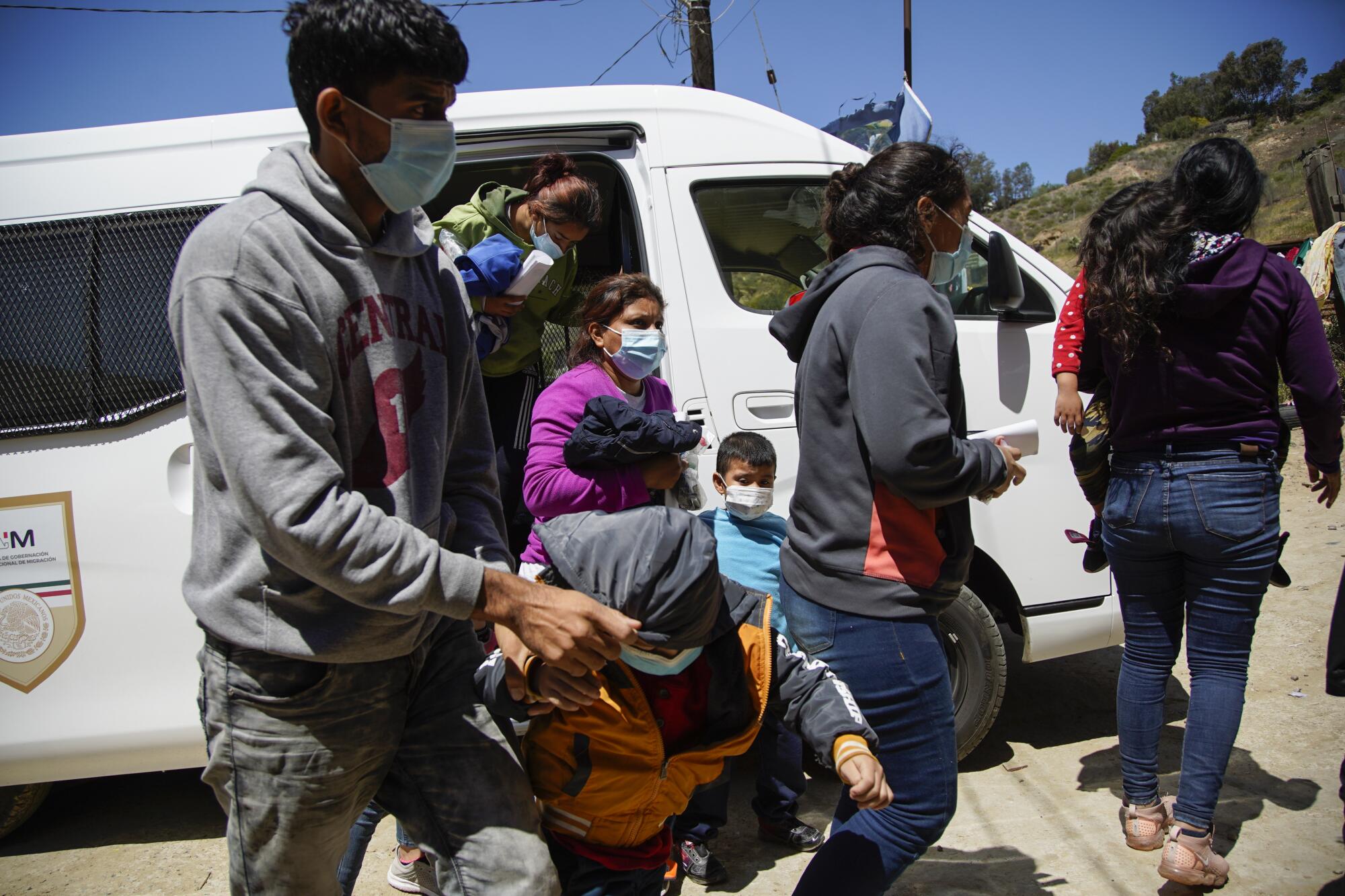 A Mexican government van drops off asylum seekers at Templo Embajadores De Jesus in Tijuana