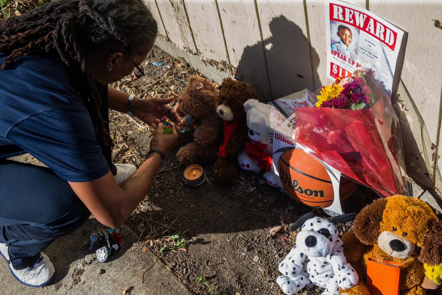 A member of St. Sabina Catholic Church prays Nov. 3, 2015, in the alley in the Gresham neighborhood where Tyshawn Lee, 9, was fatally shot a day earlier.