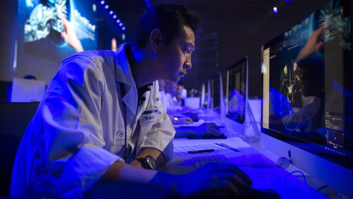 A doctor examines a magnetic resonance image of a human brain during the competition against an artificial intelligence "physician" at the China National Convention Center in Beijing on June 30, 2018.