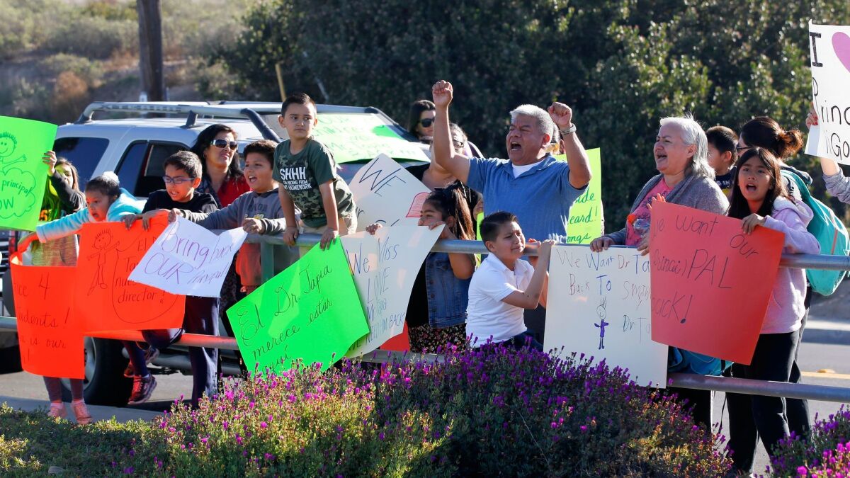 Parents and students from Smythe Elementary School stood outside the San Ysidro School District office to show support for the school principal Joel Tapia.