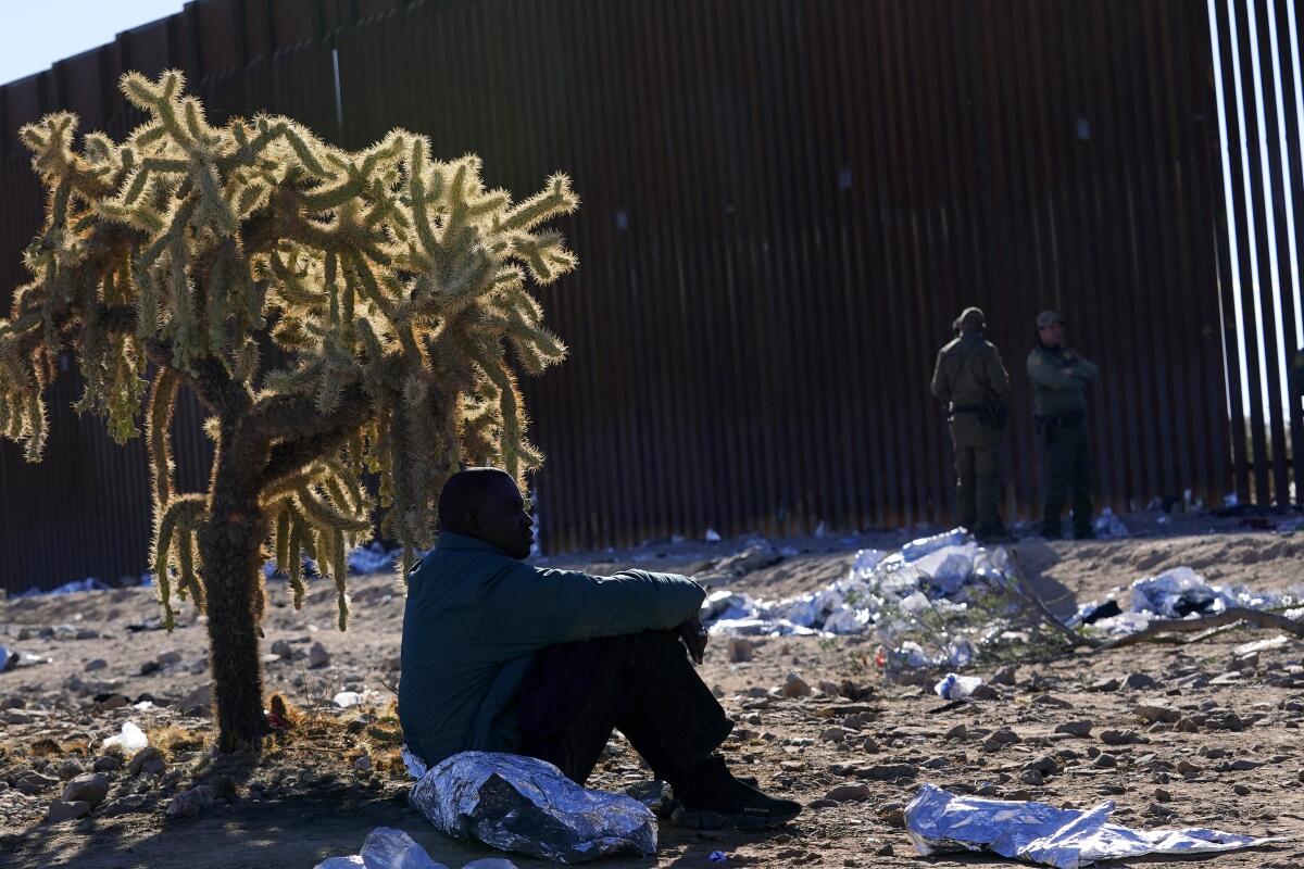Un migrante se sienta a la sombra de un cactus saltarín del desierto 