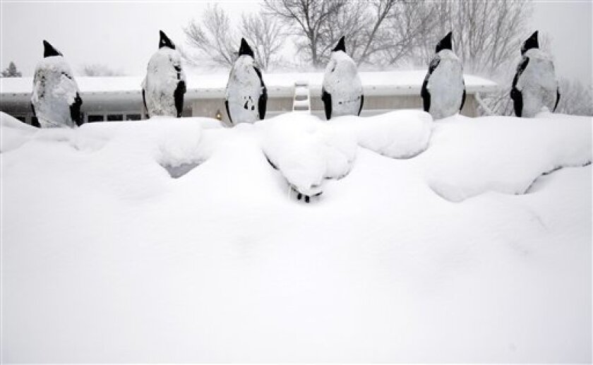 Plastic penguins adorn a snow covered sandbag levee that surrounds an evacuated home in blizzard conditions along 76th Ave. S., in Fargo, N.D., as Red River floodwaters continue to drop Tuesday, March 31, 2009. (AP Photo/Carolyn Kaster)