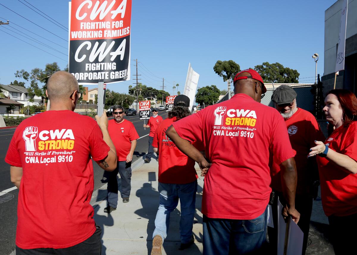 Members of the Communications Workers of America Local 9510 picket outside the Huntington Beach Frontier office on Thursday.