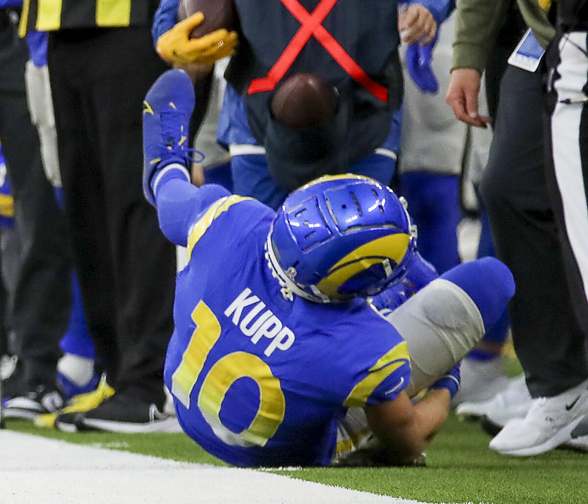 Rams receiver Cooper Kupp holds his injured right leg after failing to make a catch in the fourth quarter against Arizona.