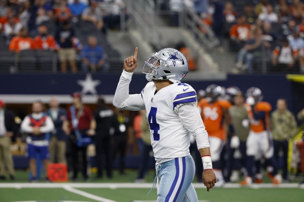 Dallas Cowboys' Dak Prescott (4) celebrates throwing a touchdown pass to Malik Turner in the second half of an NFL football game against the Denver Broncos in Arlington, Texas, Sunday, Nov. 7, 2021. (AP Photo/Ron Jenkins)