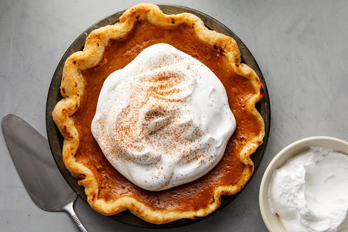 A pumpkin pie with whipped cream on top.