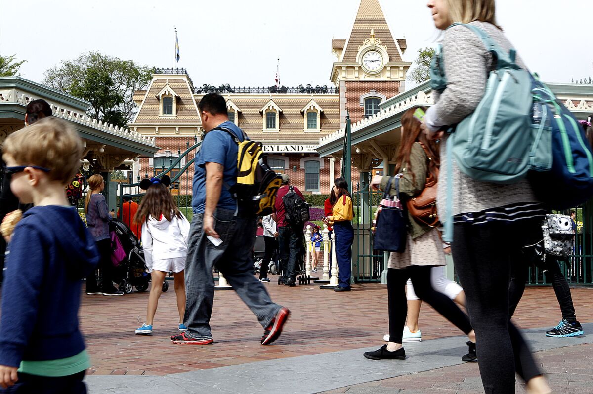 Visitors pass by the entrance gate to Disneyland. The Walt Disney Co. has purchased property near the amusement park, sparking speculation about an expansion.