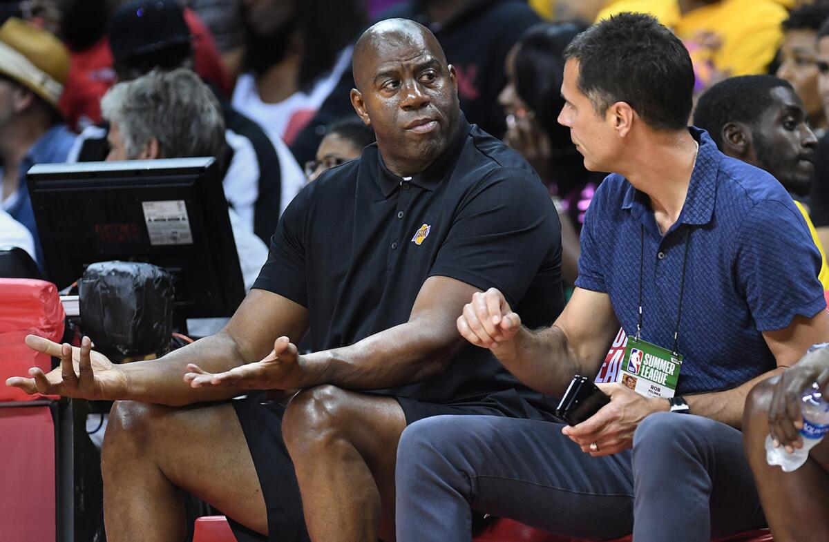 Magic Johnson and Lakers general manager Rob Pelinka sit courtside during a summer league game against the Clippers in 2018.